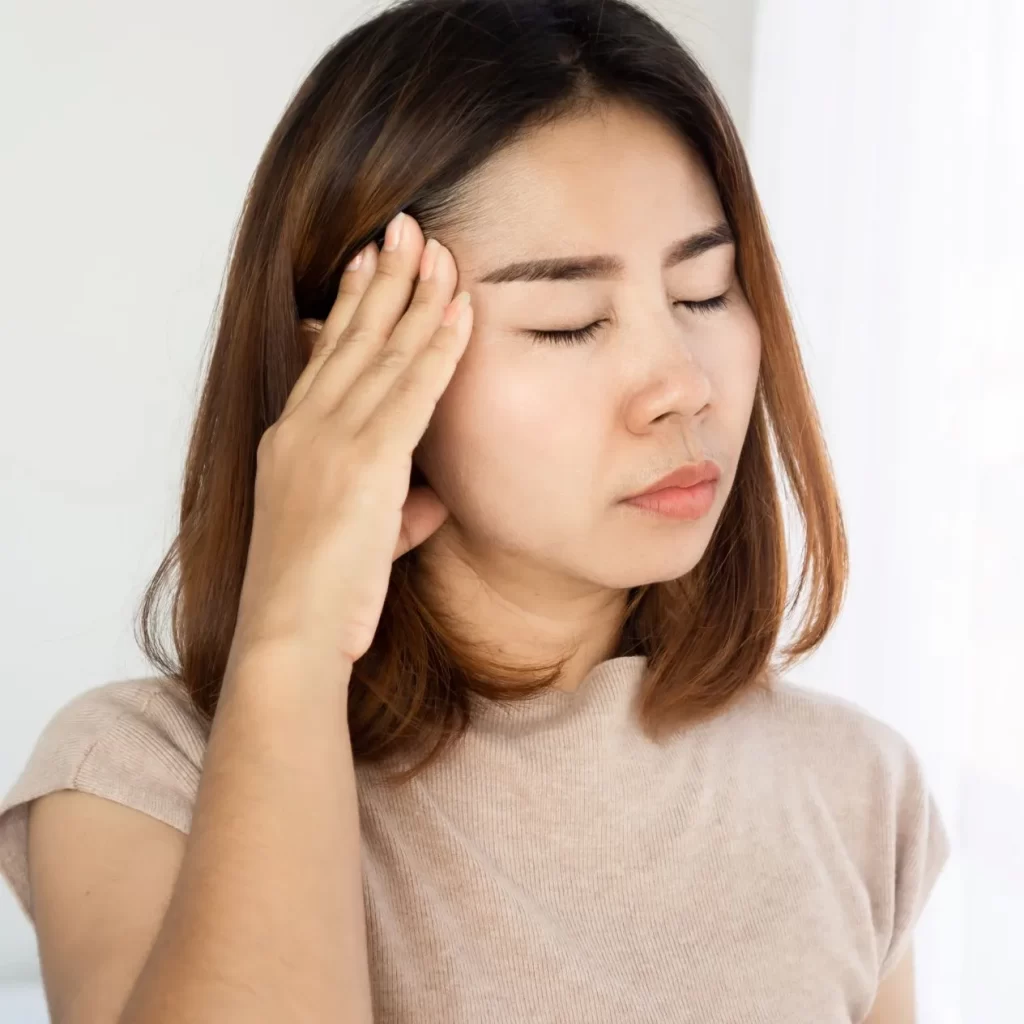 Woman holding head from a balance disorder