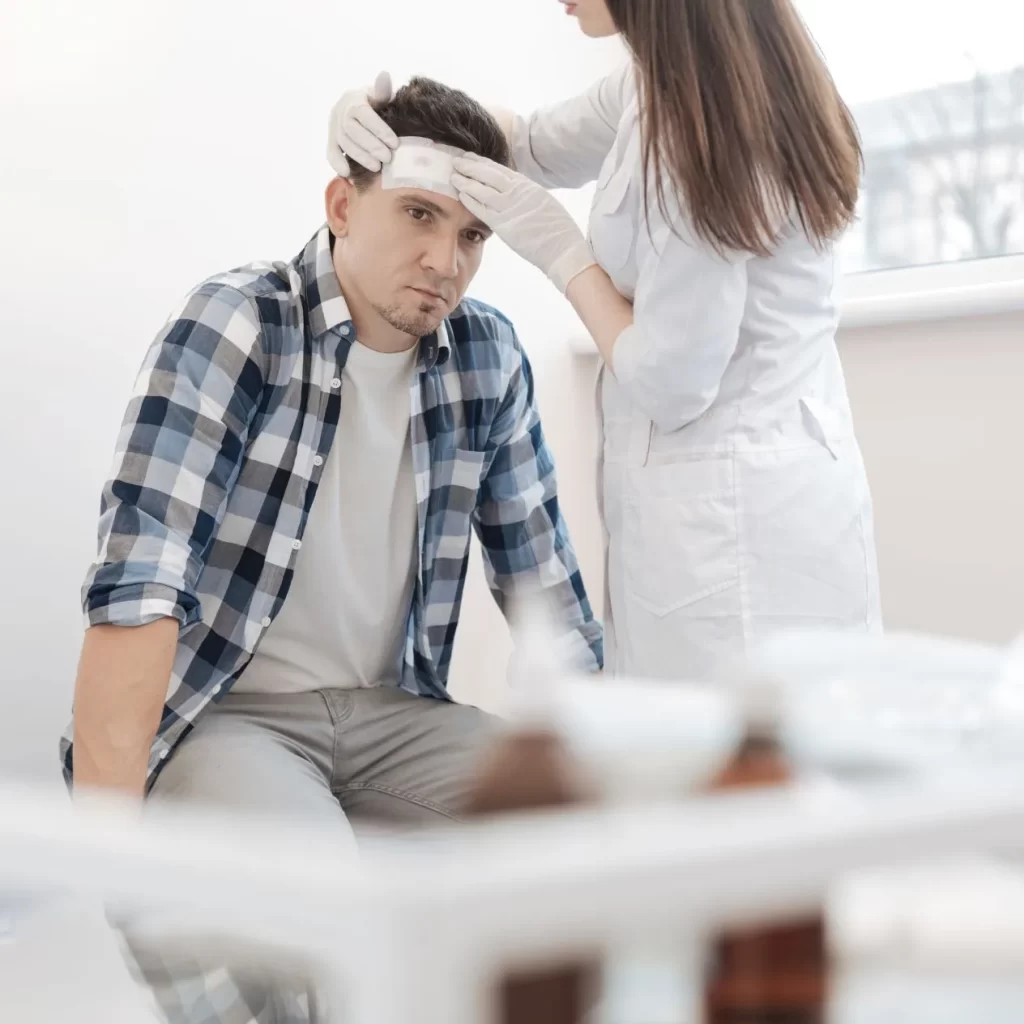 Man receiving concussion treatment from a doctor