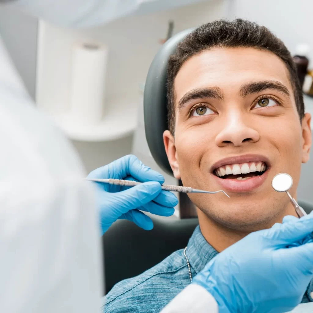 Man smiling at cosmetic dentist with cosmetic teeth