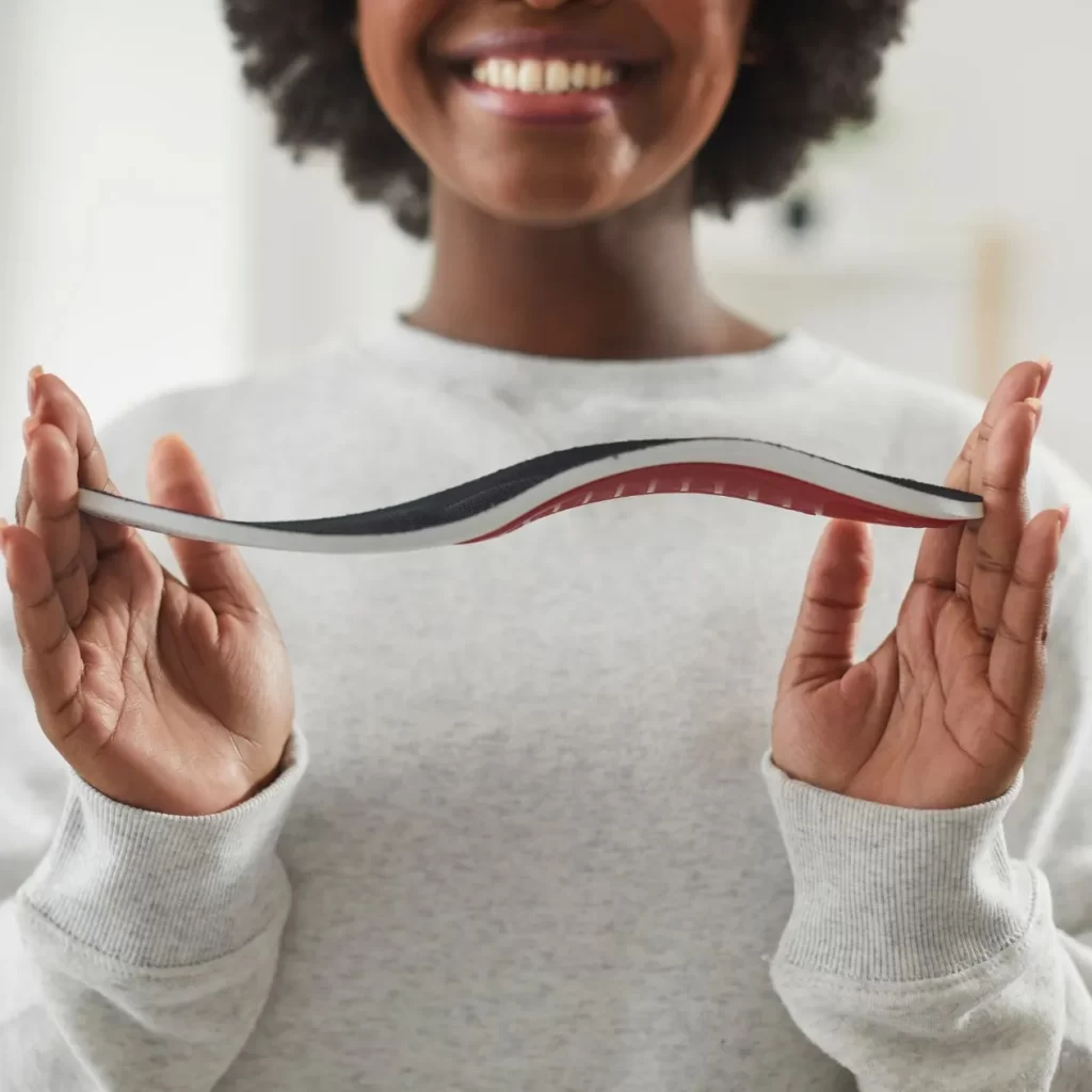 Woman holding custom orthotics for shoes