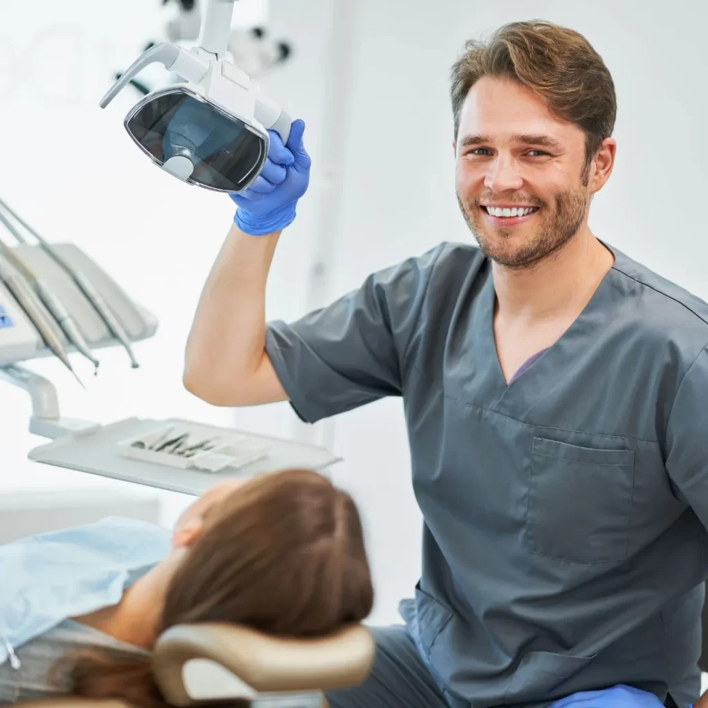 A male dental hygienist conducting a dental checkup