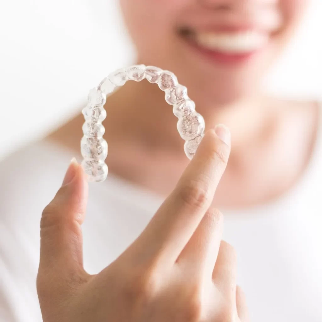 Hand holding Invisalign clear aligner