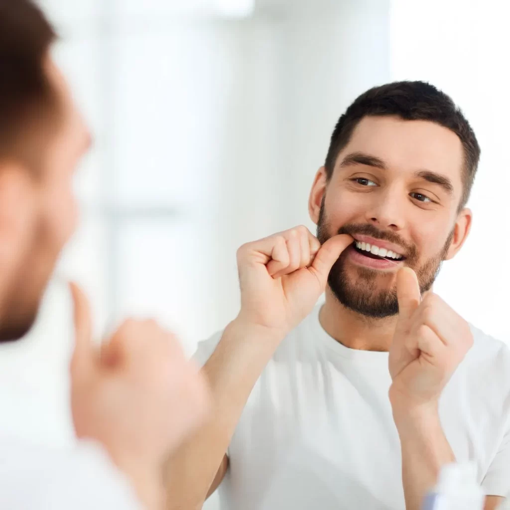 Man flossing and noticing lost crown from tooth