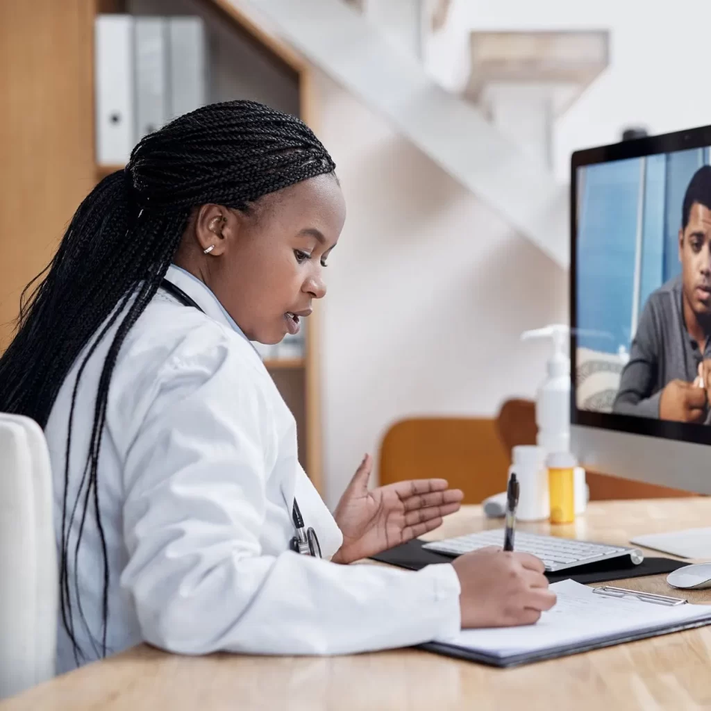 Doctor having a virtual visit with a patient and writing a medical note
