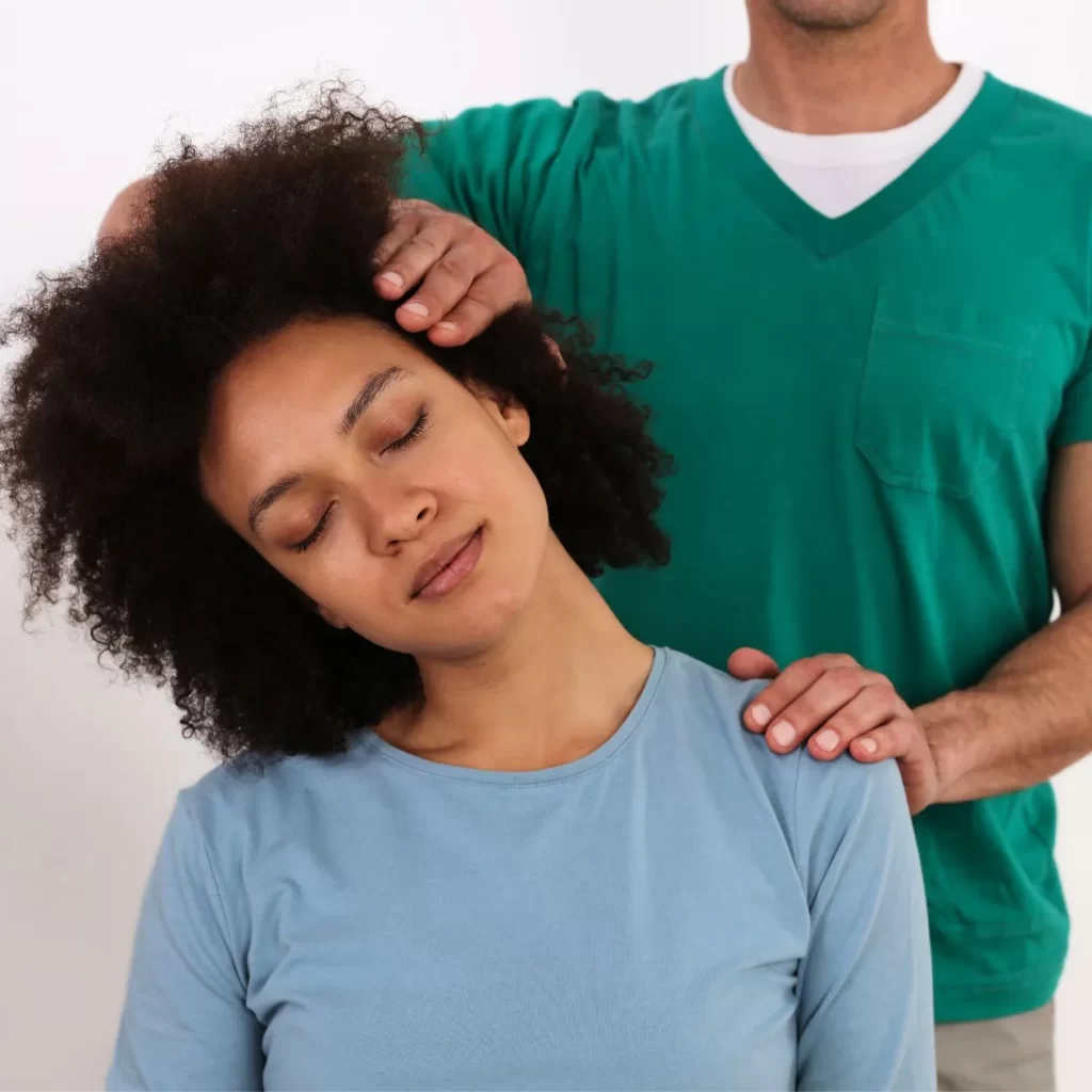 Osteopath helping patient with sore neck and shoulders