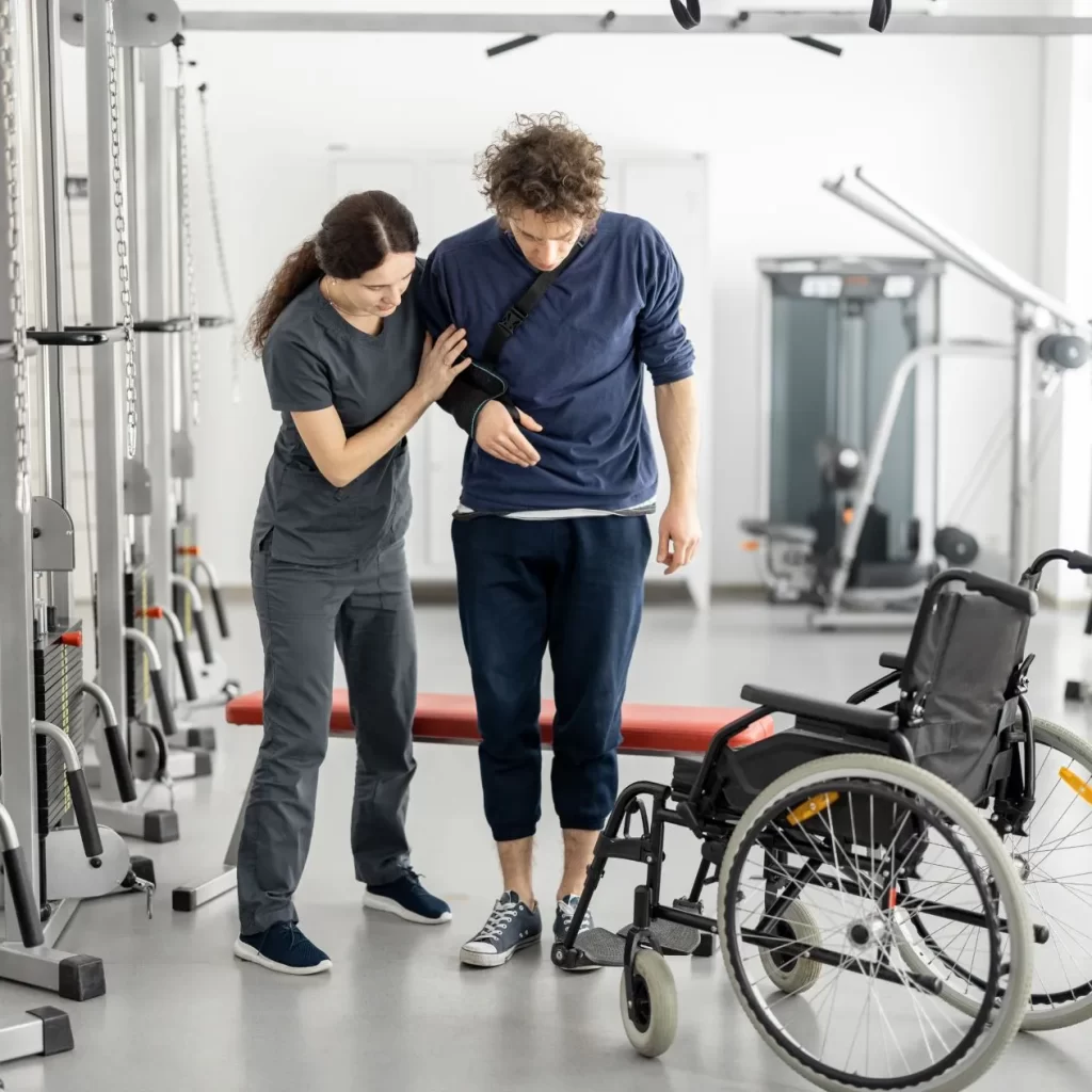 Woman helping a man in rehabilitation care