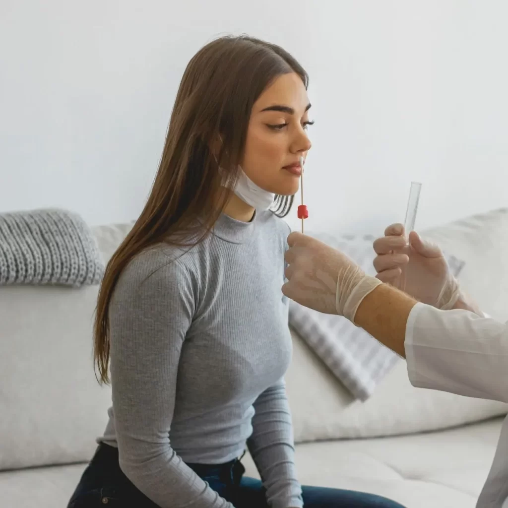 A woman undergoing COVID-19 testing administered by a doctor.