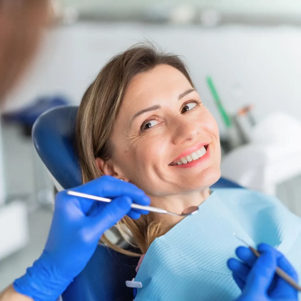 Woman smiling in dental chair before teeth whitening treatment