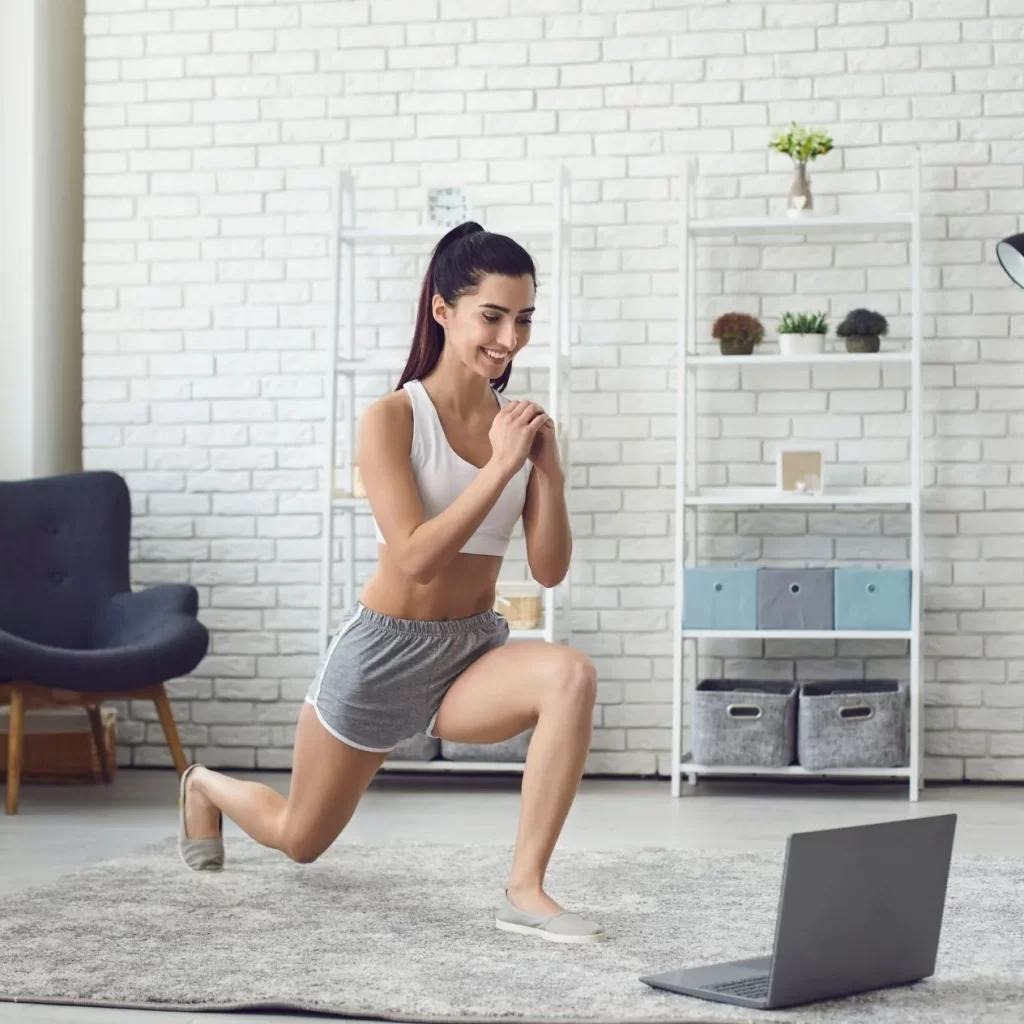 Woman working out with a laptop during virtual physiotherapy