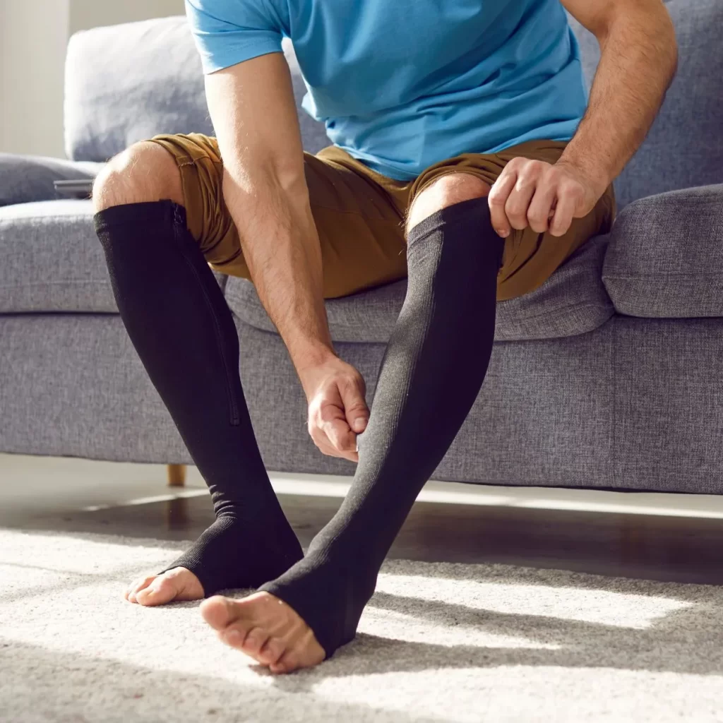 man putting compression socks on his legs