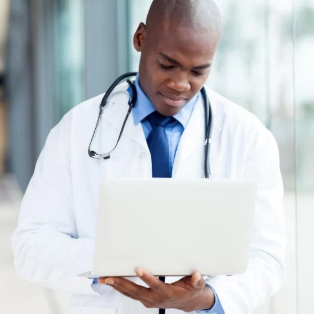 male sports medicine doctor looking at a laptop