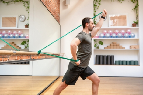 man in rehab session using resistance bands