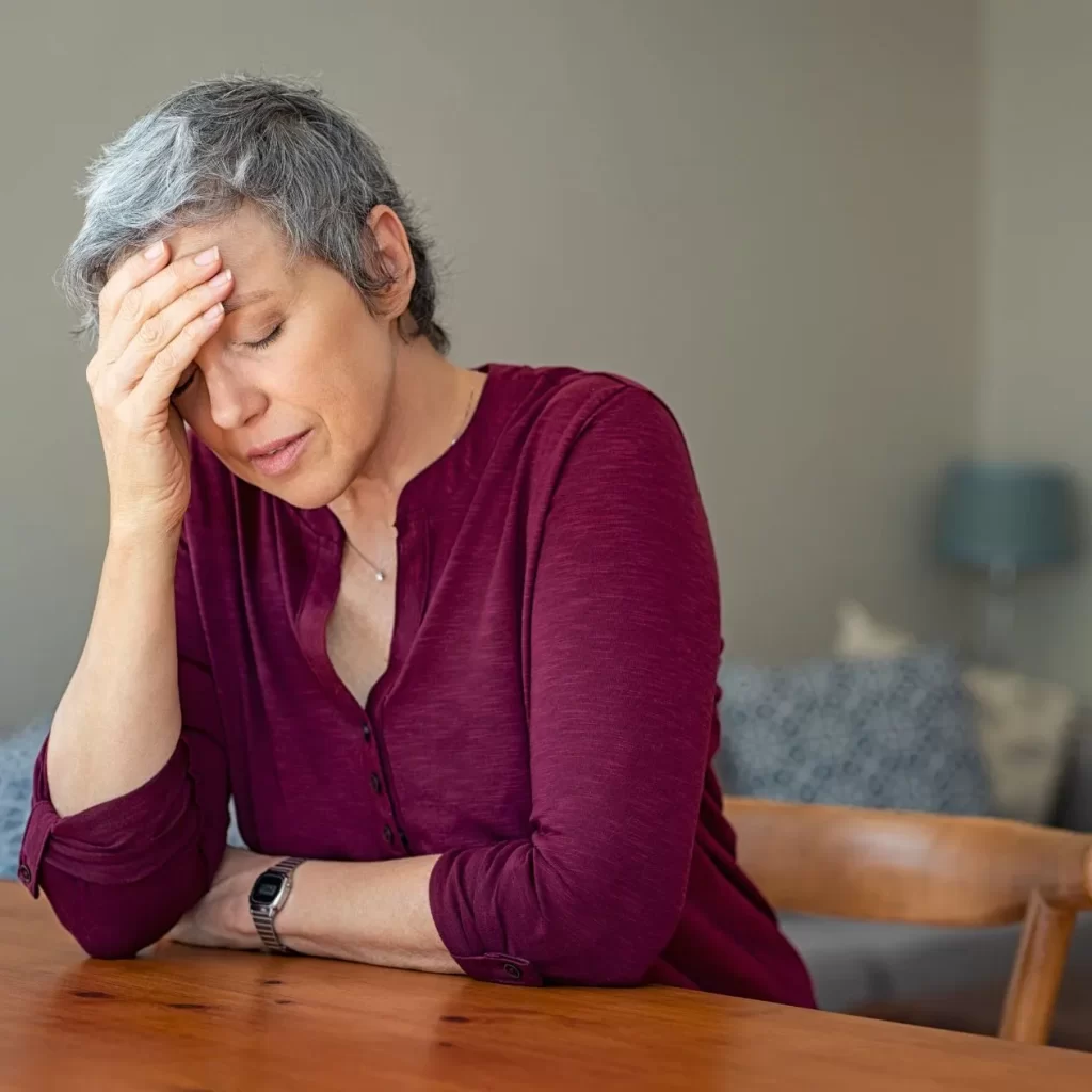 Older woman stressed out holding her forehead