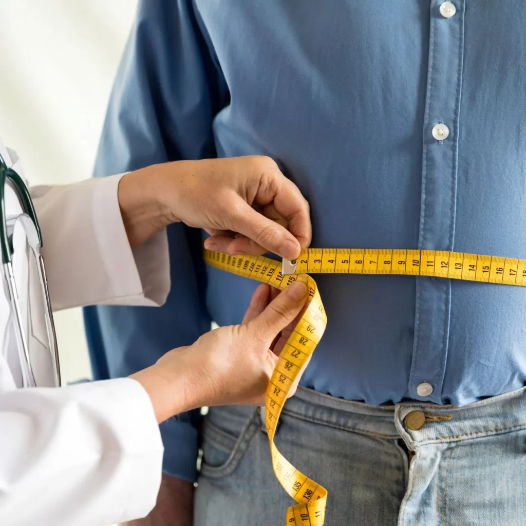Weight loss patient with measuring tape around waist