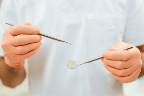 Dentist holding dental tools for appointment