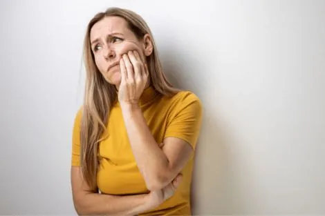 Woman holding mouth from wisdom tooth pain