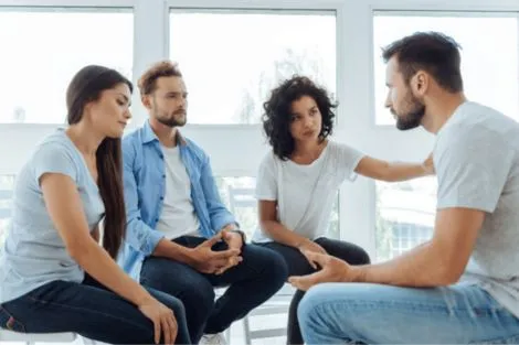 man with depression in a group of supportive friends